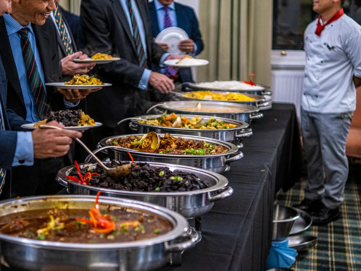 Guests select food from a catered buffet.