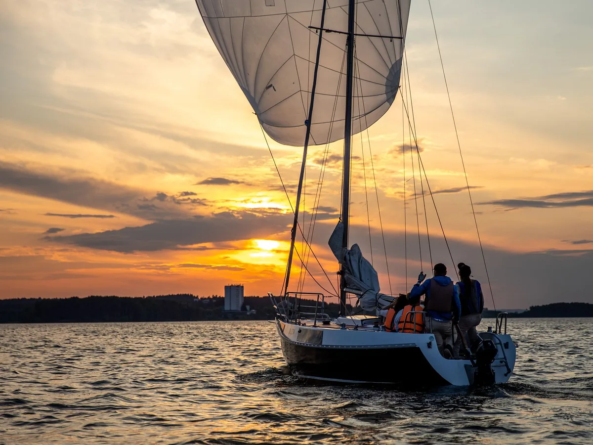 A sailing boat on the water at sunset.