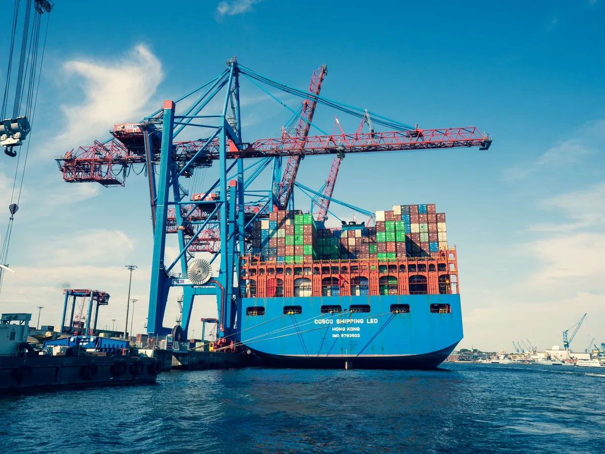 Shipping containers and cranes at a freight port.
