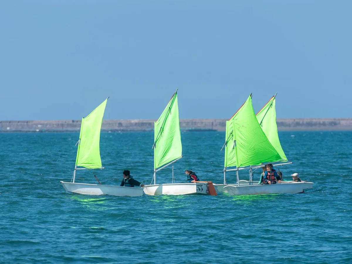 Young sailors learn to navigate small sailing boats.