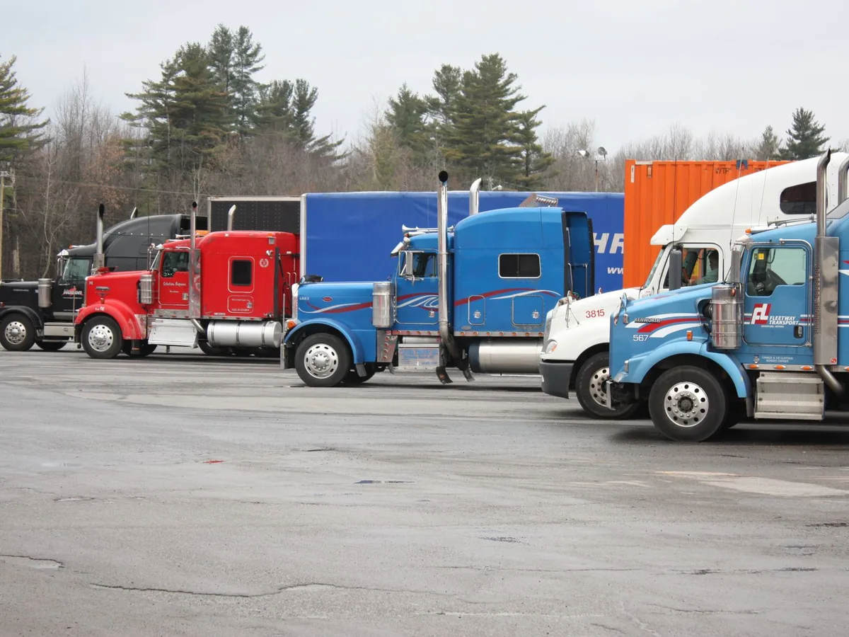 Colourful semi-trucks parked in an open lot.