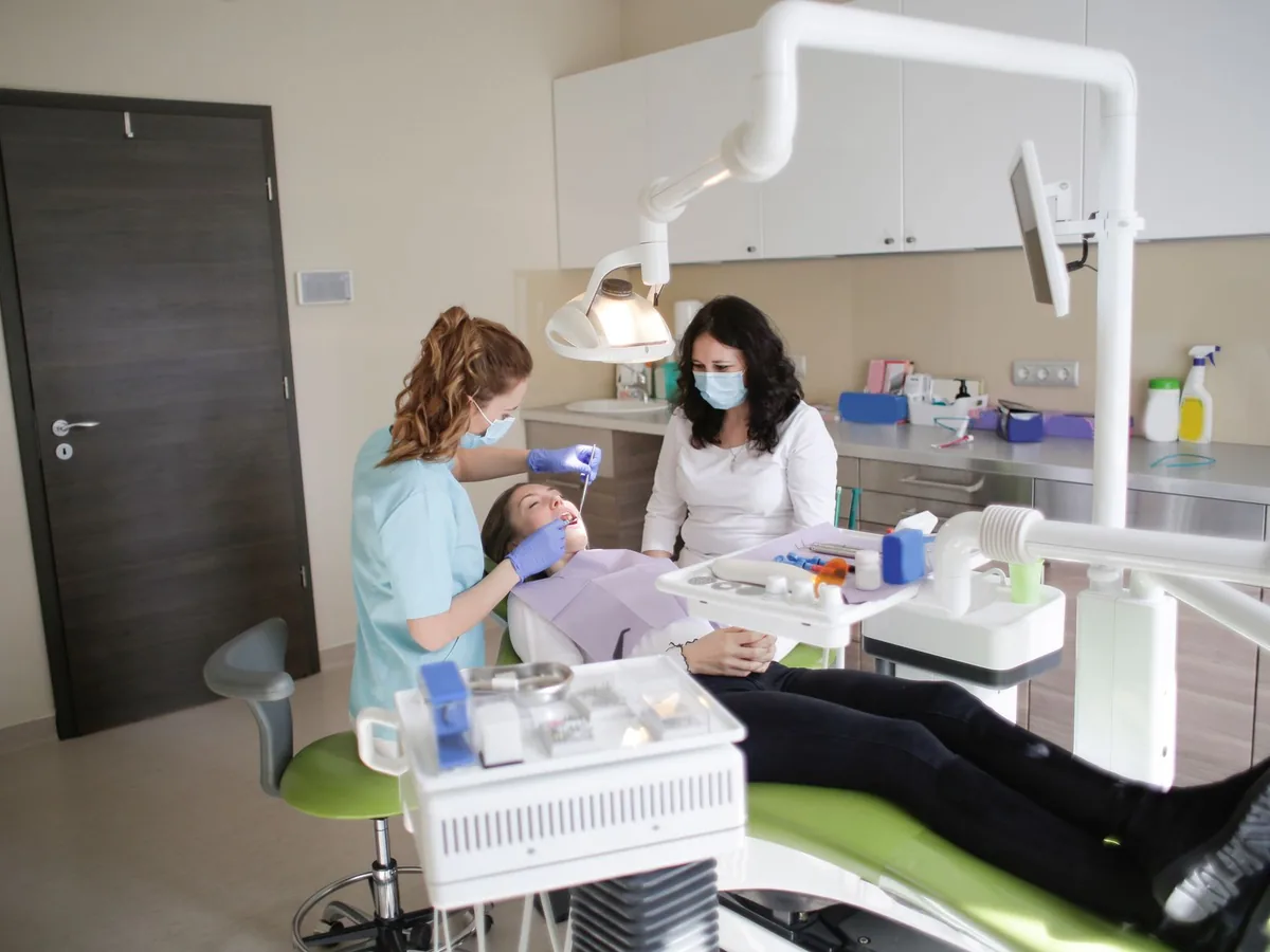 A dentist examines a patient’s teeth.