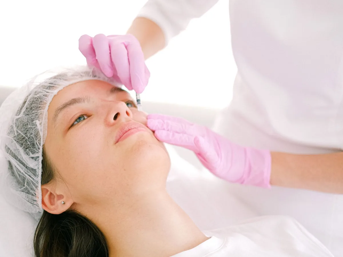 A practitioner gives a client a cosmetic facial injection.