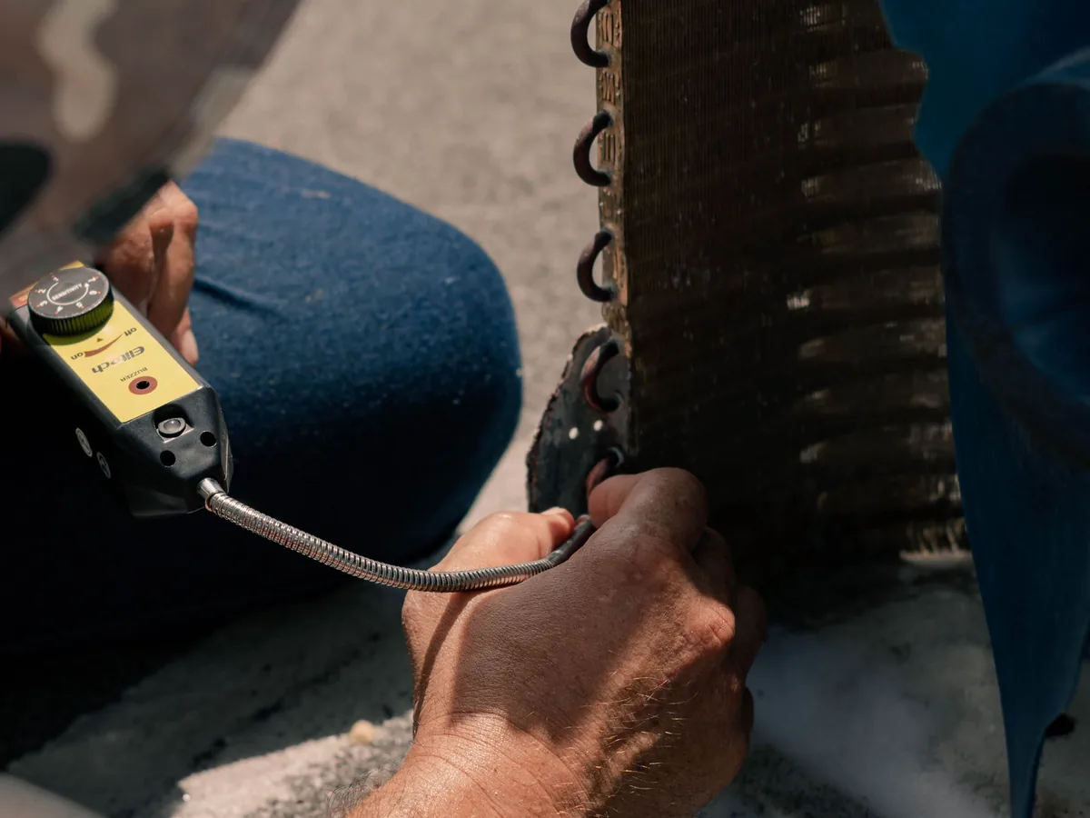 A technician repairs an air conditioning unit.