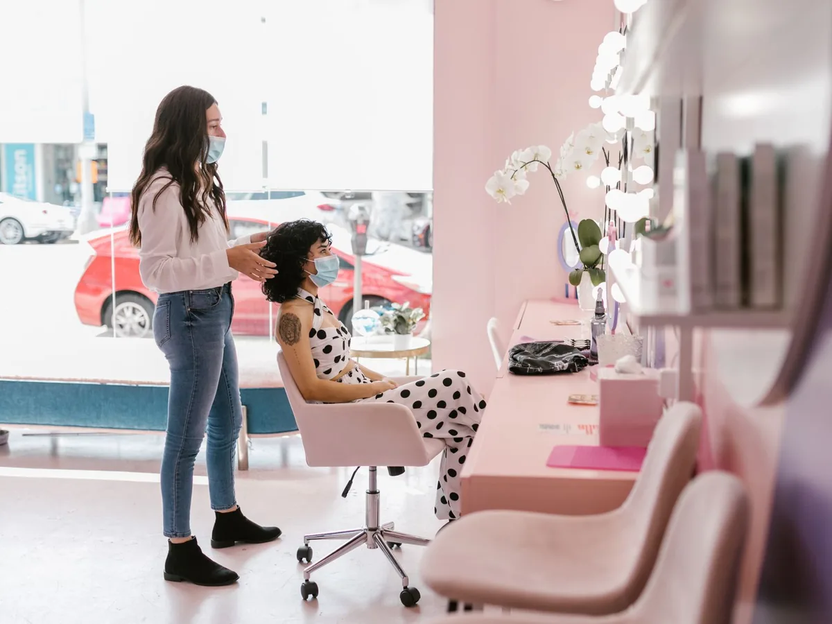 A client sits in a chair at a beauty salon.