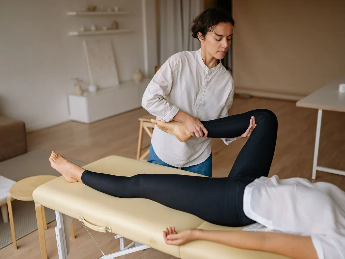 A massage therapist provides a rejuvenating leg treatment in a calming spa environment.