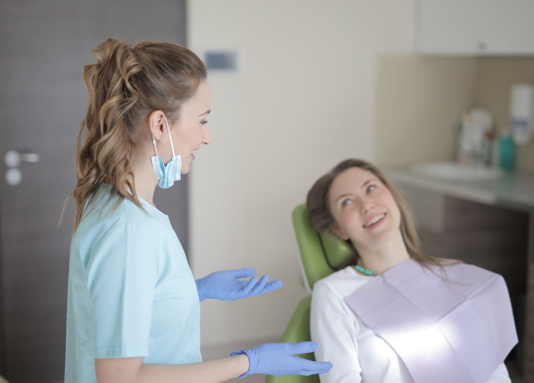 Dentist speaking calmly with a patient in a treatment room